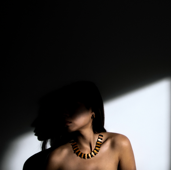 Trace handmade Irish wooden necklace modelled by Alba photographed in shadow